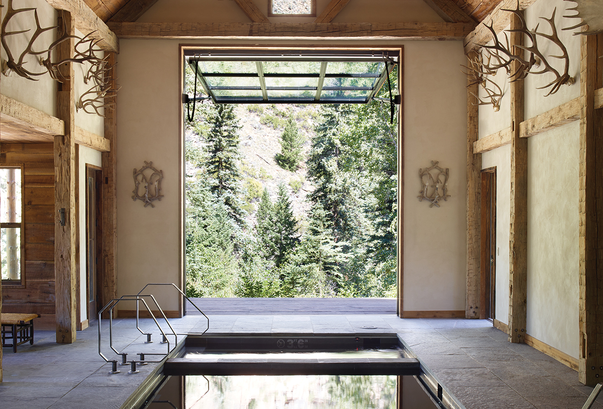 Snowy cabin in the mountains with a river running next to it